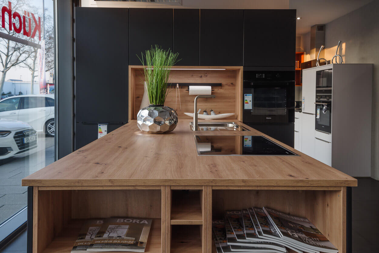 Innenaufnahme von schwarzer Küche mit Holzelementen im Küchenstudio Küchencenter Speyer